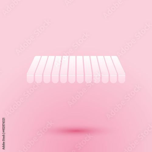 Paper cut Striped awning icon isolated on pink background. Outdoor sunshade sign. Awning canopy for shops, cafes and street restaurants. Paper art style. Vector.