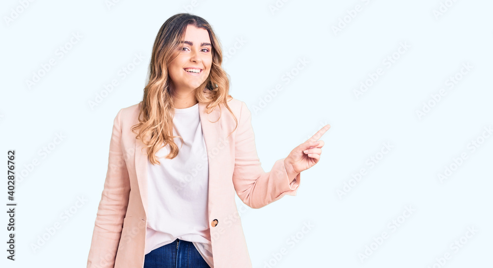 Young caucasian woman wearing business clothes with a big smile on face, pointing with hand finger to the side looking at the camera. Young caucasian woman wearing business clothes with a big smile on face, pointing with hand finger to the side looking at the camera.