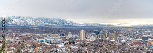 Panorama of Salt Lake City with snowy mountain and gray cloudy sky in winter