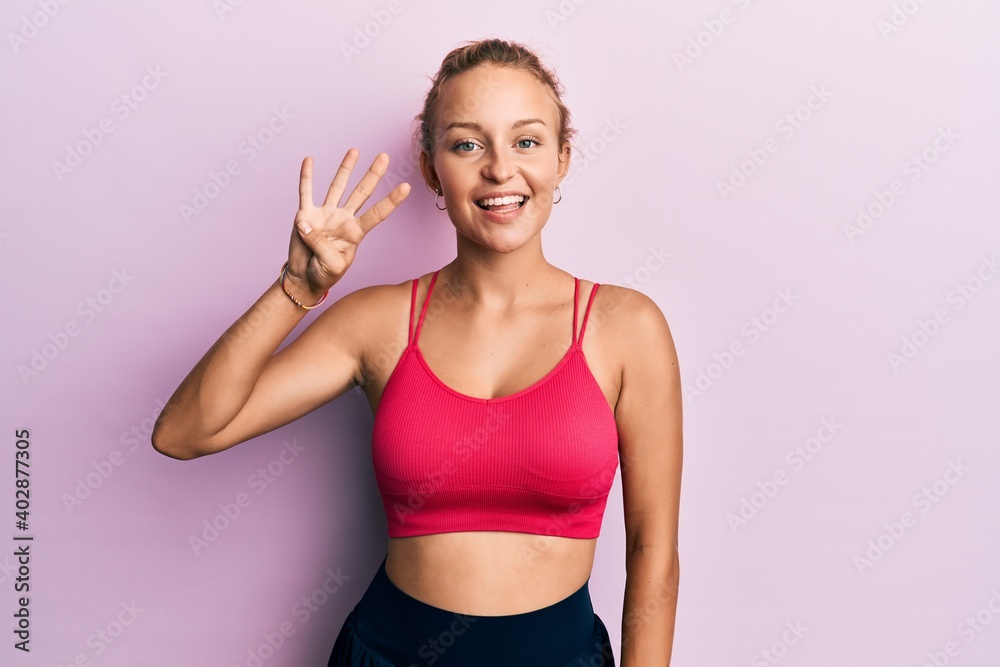 Beautiful caucasian woman wearing sportswear showing and pointing up with fingers number four while smiling confident and happy.