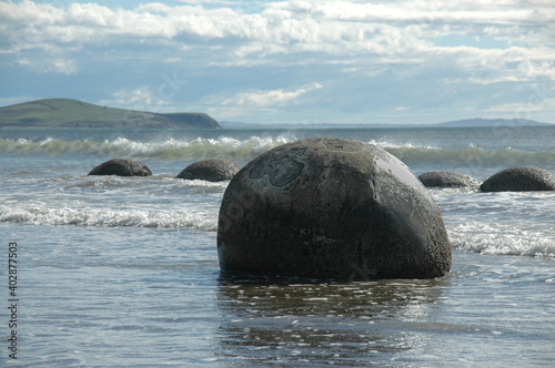 Fotografiet Moeraki Boulders on the beach in the water New Zealand