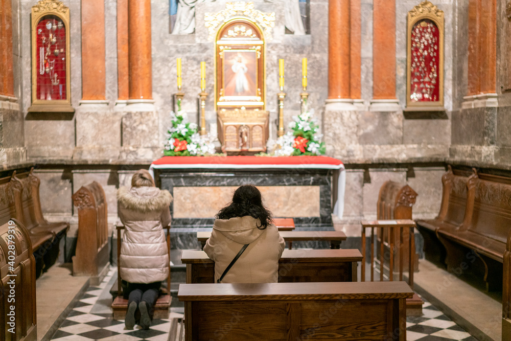 A woman in a temple prays to God. Woman praying in front of altar. Praying woman in front of altar. selected focus