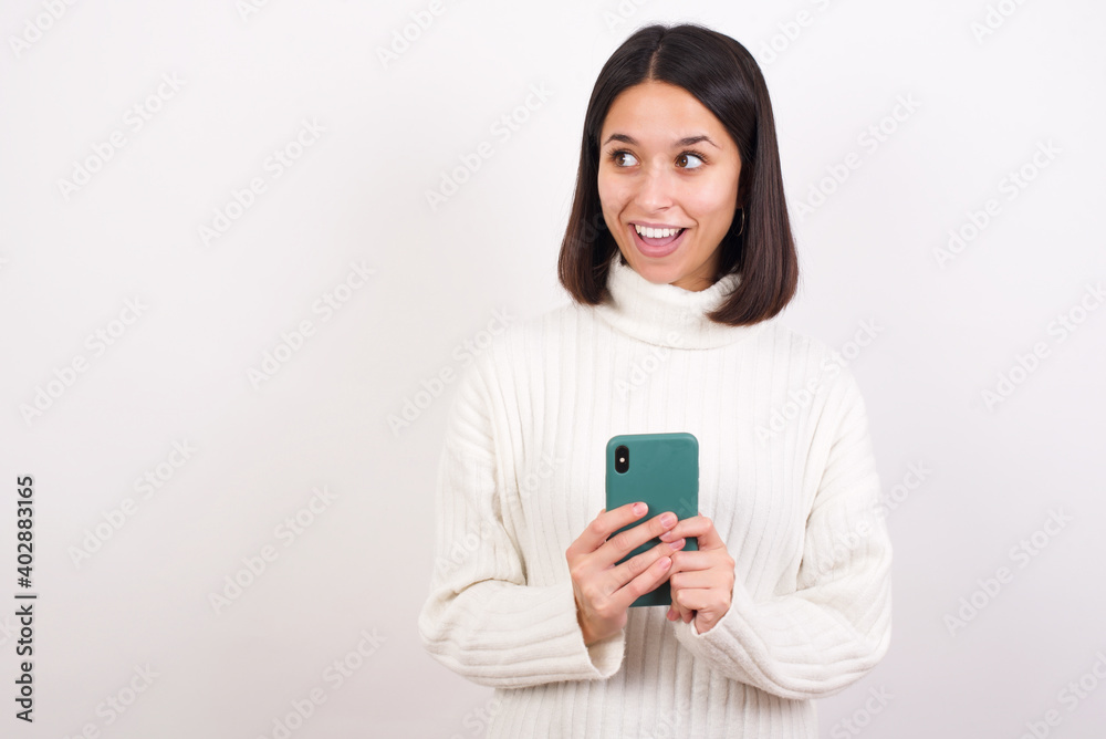 Copyspace photo of Young brunette woman wearing white knitted sweater against white background stupor with something occurring in social media Copyspace photo of Young brunette woman wearing white knitted sweater against white background stupor with something occurring in social media