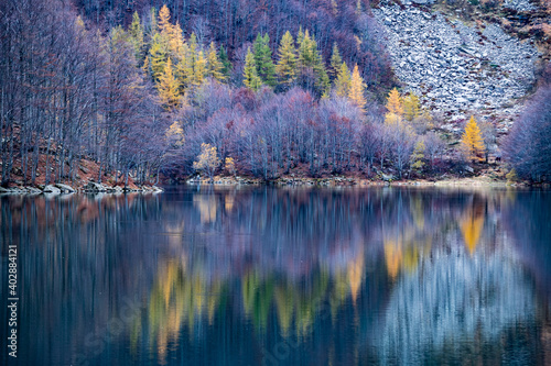 Reflections of Santo Lake of Modena, surrounded by autumn colours of nature, Italy