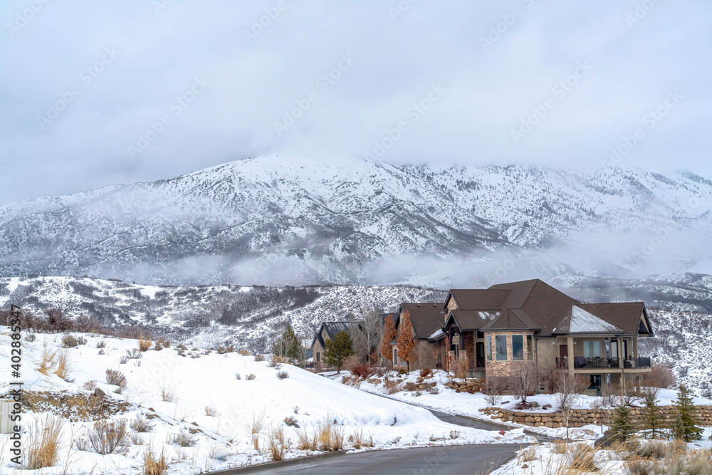 Homes blending with the snow covered terrain against Wasatch Mountain in winter