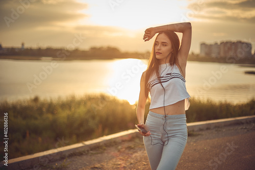 Young beautiful caucasian girl listening to music with smartphone walking in the city with headphones smiling - relax, youth, emancipation concept photo