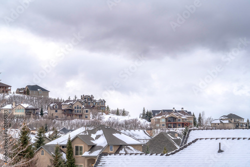 Mountain homes on a cold snowy setting beneath gray overcast sky in winter