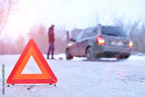car repair on the road in winter. Car triangle on winter road. Problem with vehicle on snowy road. Broken cars concept. banner of snowy winter road.