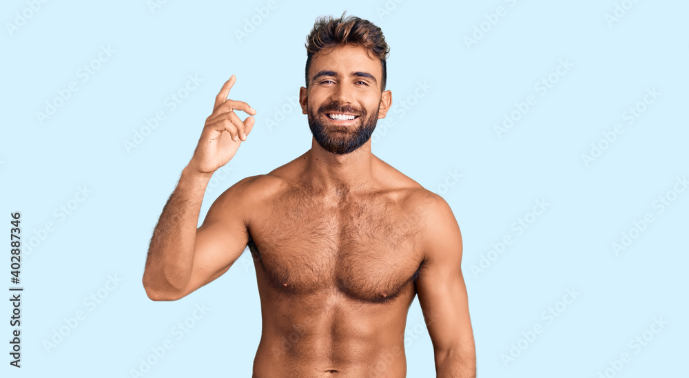 Young hispanic man wearing swimwear shirtless pointing finger up with successful idea. exited and happy. number one. Young hispanic man wearing swimwear shirtless pointing finger up with successful idea. exited and happy. number one.