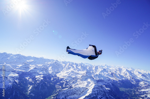 Wingsuit flier glides on his back over snowcapped mountains © Talent for Adventure