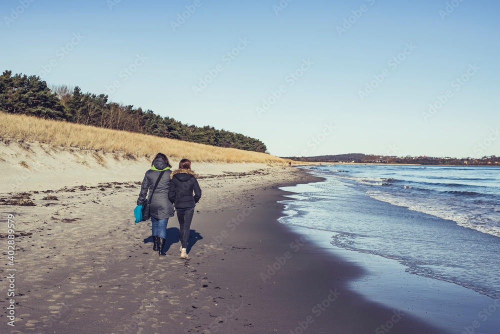Mutter und Tochter spazieren am Strand Mutter und Tochter spazieren am Strand