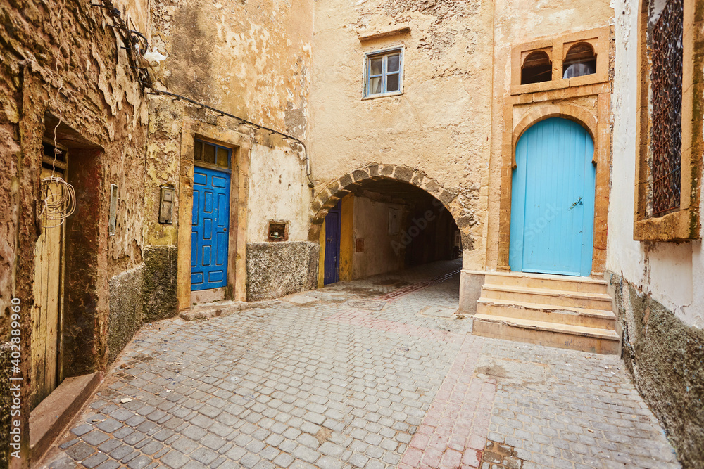 Narrow street of the old city with beige and white walls of the residential houses. Narrow street of the old city with beige and white walls of the residential houses.