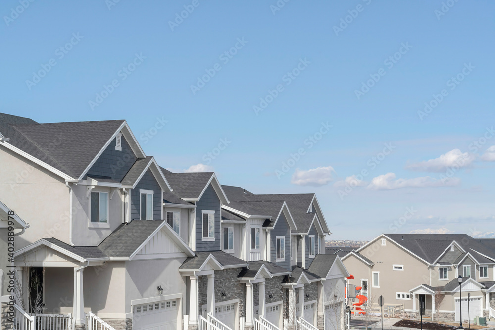 Peaceful skyscape of blue sky over suburban houses on a residential landscape