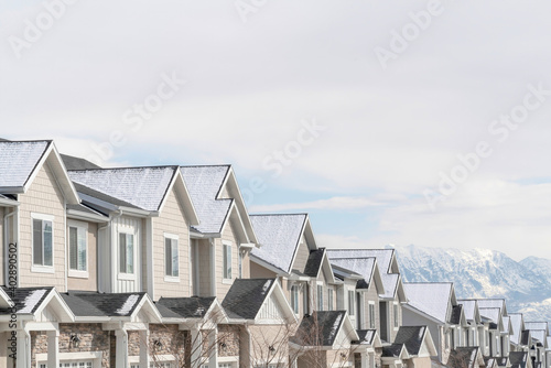 Gabled townhouses with scenic mountain and overcast sky background in winter