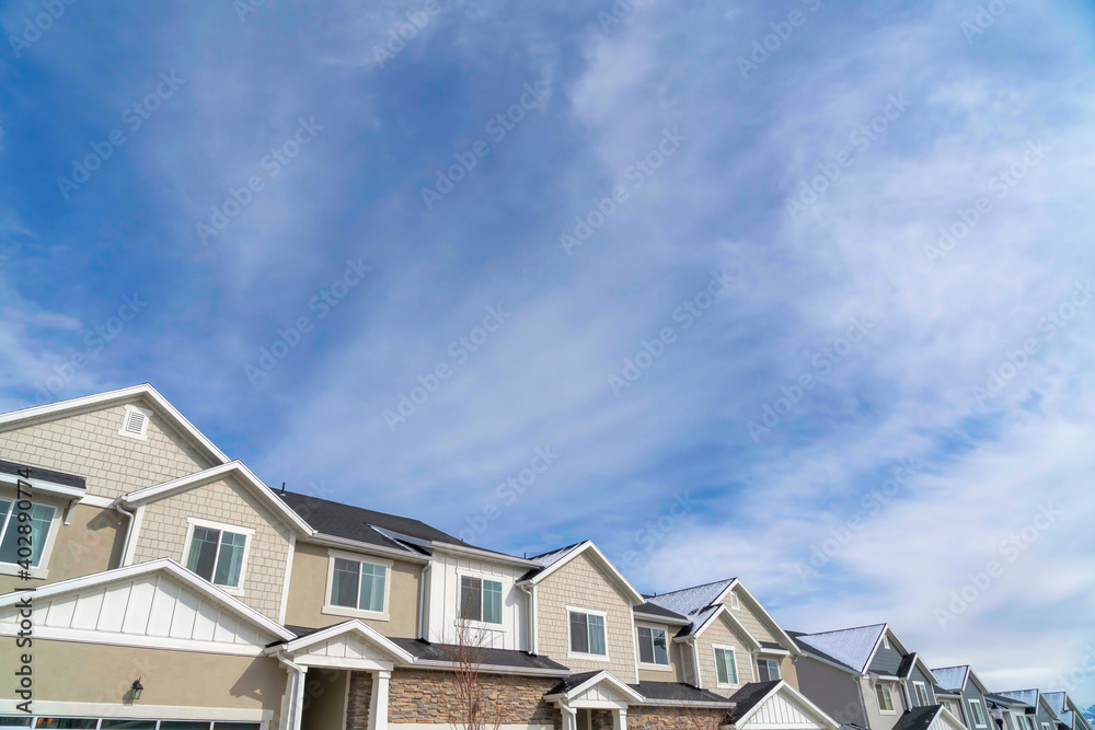 Townhouses on a residential neighborhood landscape with cloudy sky background Townhouses on a residential neighborhood landscape with cloudy sky background