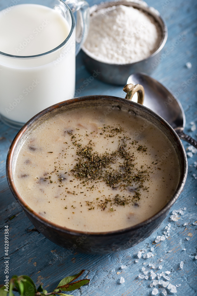 Mushroom cream soup in bowl with glass of milk on wooden background. Mushroom cream soup in bowl with glass of milk on wooden background.
