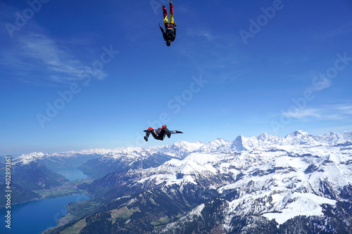 Skydivers perform tricks above snowcapped mountains © Talent for Adventure