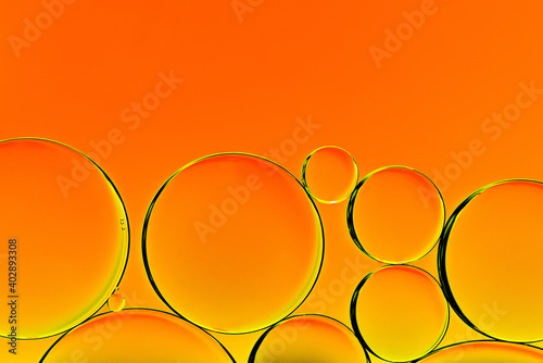 Orange oil drops. Bubbles of different sizes on orange abstract background