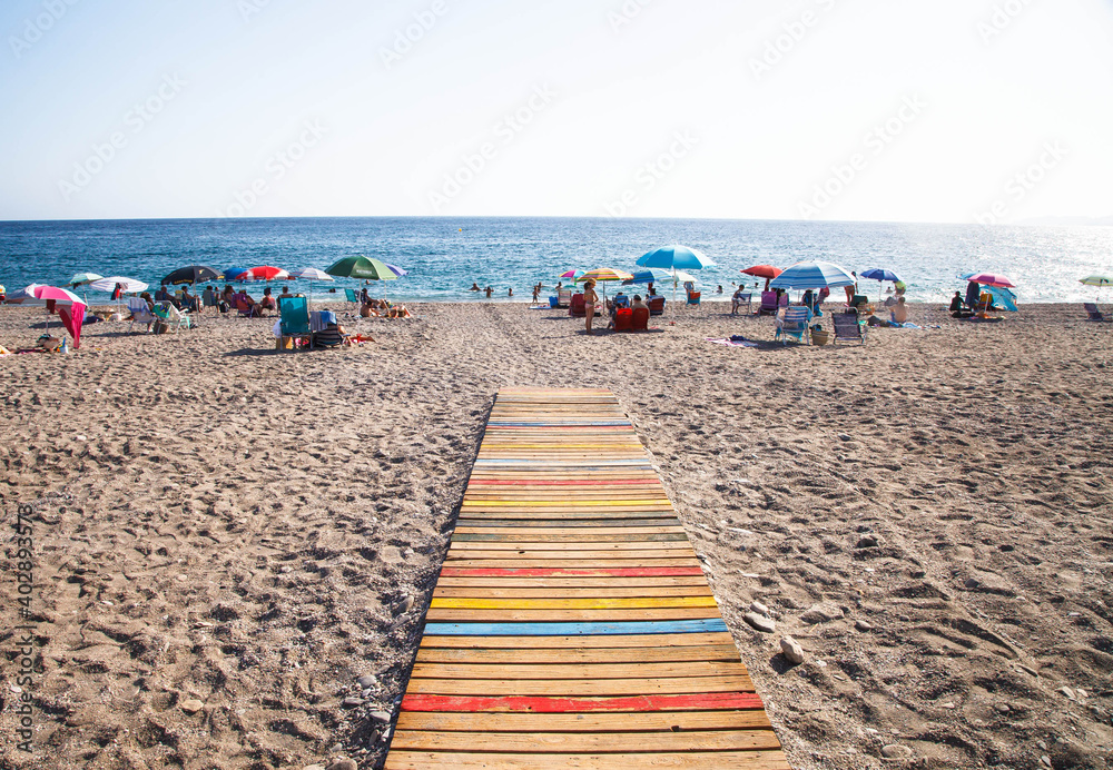 Colourful path on beach with sunbathers Colourful path on beach with sunbathers