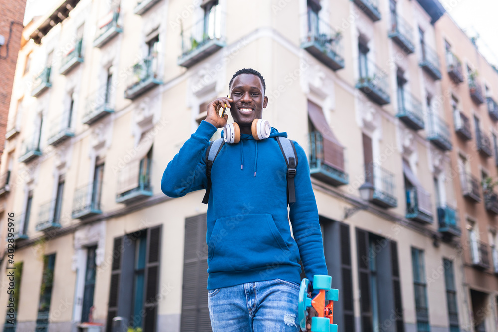 Black Man Having Phone Call Wearing Blue Sweater Outdoors.