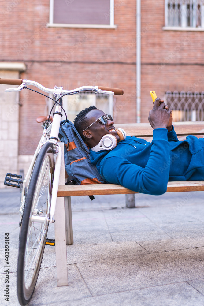 Black Man Using Cellphone Wearing Blue Sweater Outdoors. Black Man Using Cellphone Wearing Blue Sweater Outdoors.