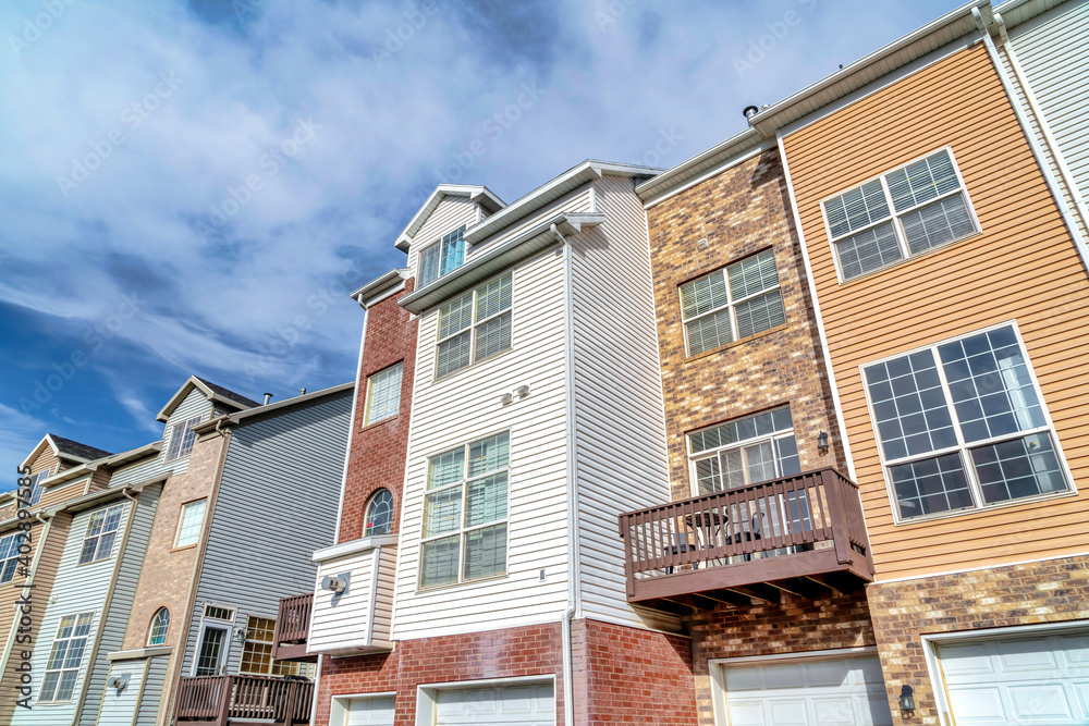 Obraz premium Townhouses on a sunny day setting with balconies overlooking scenic skyscape