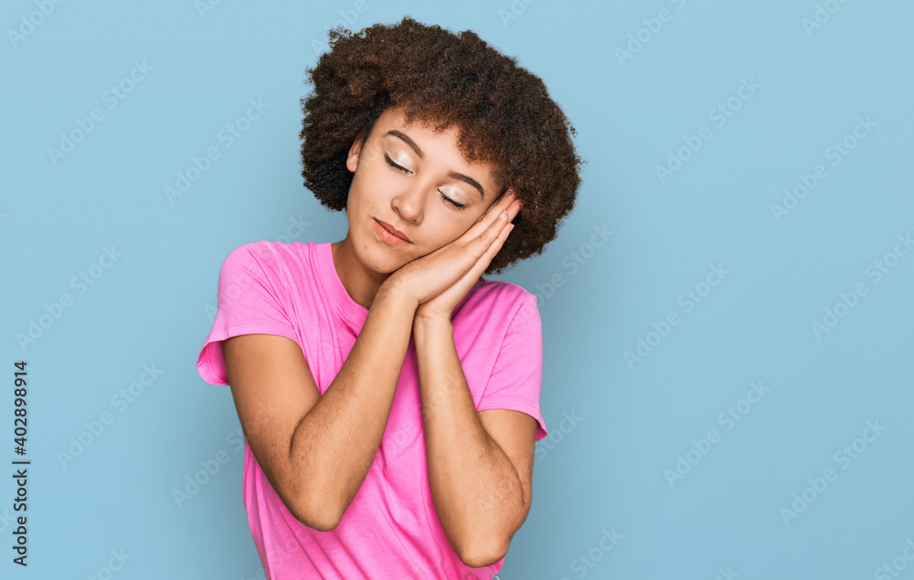 Young hispanic girl wearing casual clothes sleeping tired dreaming and posing with hands together while smiling with closed eyes.