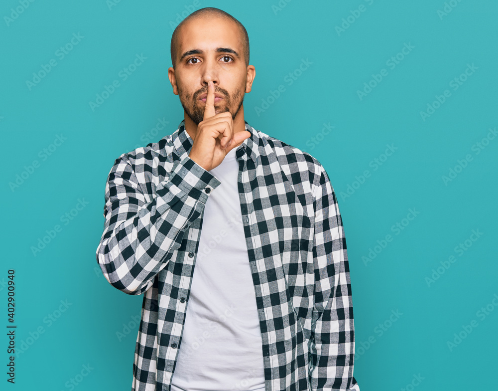 Hispanic adult man wearing casual clothes asking to be quiet with finger on lips. silence and secret concept. Hispanic adult man wearing casual clothes asking to be quiet with finger on lips. silence and secret concept.