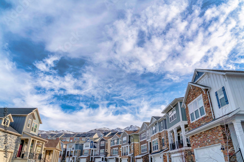 Cloudy blue sky over houses with snowy mountain peak background in winter