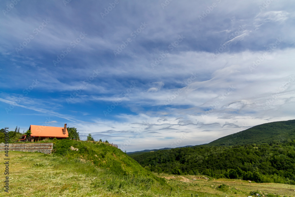 Different clouds in the blue sky and house of mountain