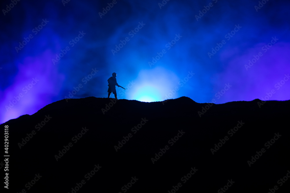 Fototapeta War Concept. Military silhouettes fighting scene on war fog sky background, World War Soldiers Silhouette Below Cloudy Skyline At night. Battle in ruined city.
