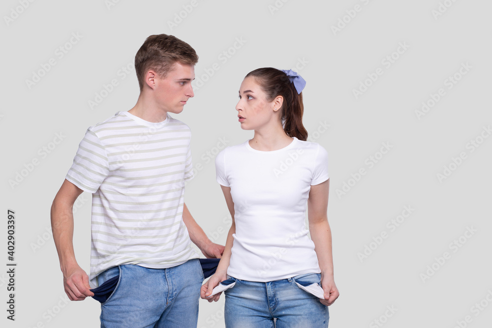 Couple Showing Empty Pockets Looking at Each Other. Family Budget. No Money, No Cash, Poor Concept. Couple Showing Empty Pockets Looking at Each Other. Family Budget. No Money, No Cash, Poor Concept.