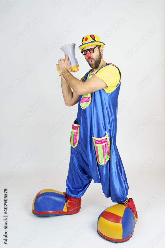 Plakat A clown in a bright blue and yellow suit, glasses and a hat plays with a megaphone.