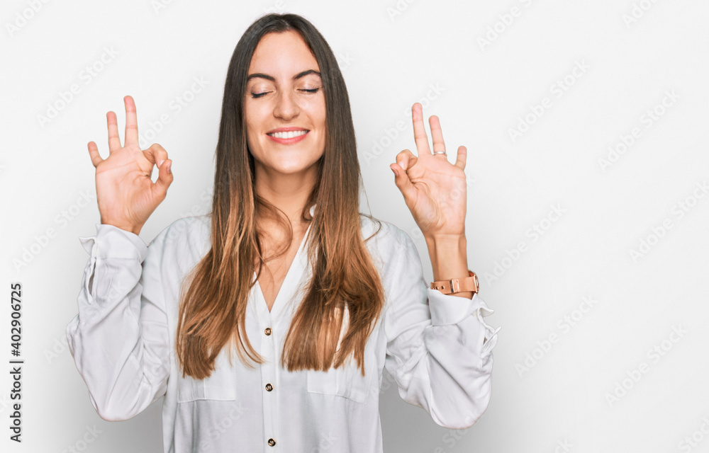 Young beautiful woman wearing casual clothes relaxed and smiling with eyes closed doing meditation gesture with fingers. yoga concept. Young beautiful woman wearing casual clothes relaxed and smiling with eyes closed doing meditation gesture with fingers. yoga concept.