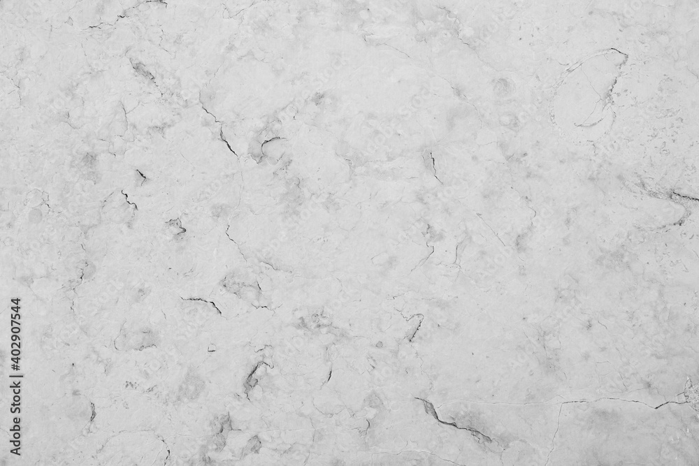 Fototapeta premium Close-up of an aged and cracked smooth natural marble stone wall or flooring. High resolution full frame textured background in black and white.