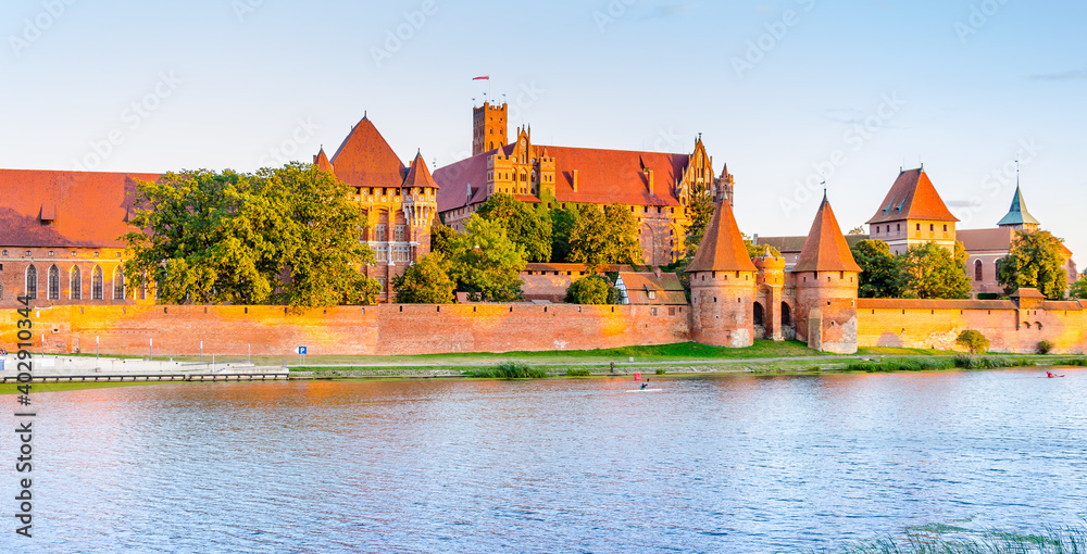 Obraz premium Panoramic view of the Teutonic Order Castle in Malbork during sunset.