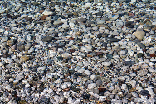 Pebbles in clear sea water in the sunlight