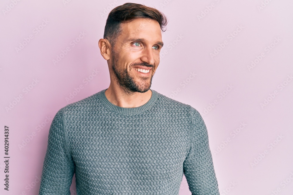 Handsome man with beard wearing casual winter sweater looking to side, relax profile pose with natural face and confident smile. Handsome man with beard wearing casual winter sweater looking to side, relax profile pose with natural face and confident smile.