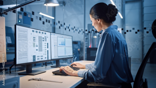 Billede på lærred Factory Office: Portrait of Beautiful and Confident Female Industrial Engineer Working on Computer, on Screen Industrial Electronics Design Software