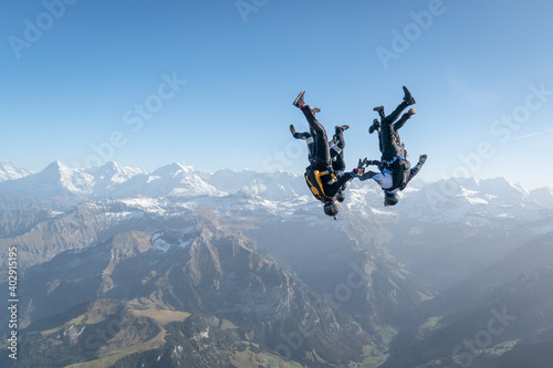 Skydivers perform stunts over Swiss Alps photo