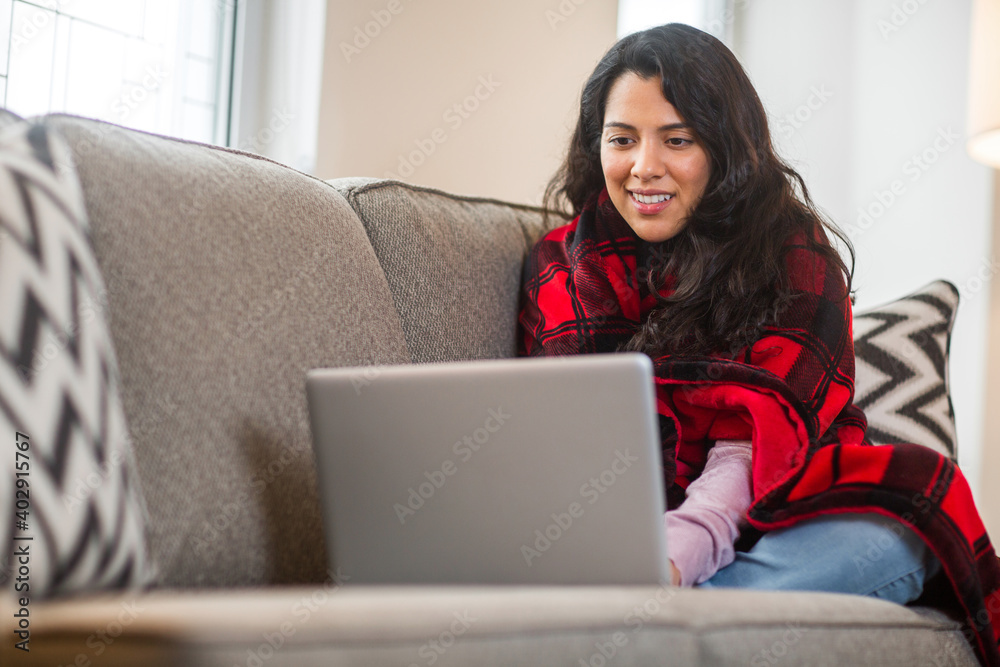 Young woman working at home sitting on a sofa. Young woman working at home sitting on a sofa.