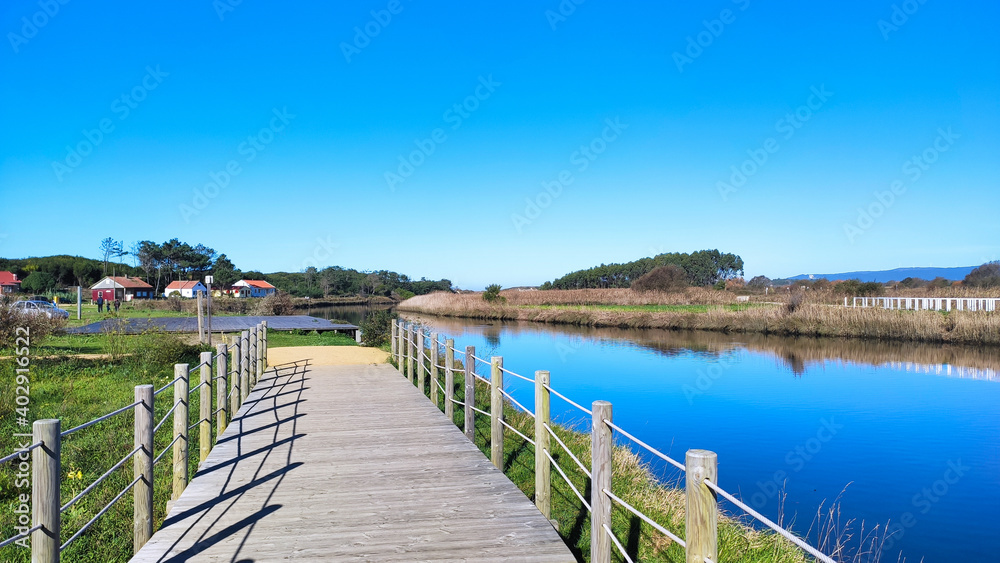 The mouth and estuary of Neiva River in Antas, Esposende, Portugal. The Ecovia Litoral Norte (North Coast Ecoway) wooden boardwalk. The mouth and estuary of Neiva River in Antas, Esposende, Portugal. The Ecovia Litoral Norte (North Coast Ecoway) wooden boardwalk.