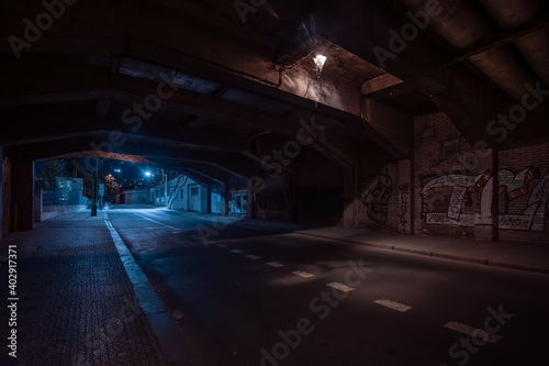 Dark empty dirty grunge underground concrete tunel with a road during mystic night with blue street lights