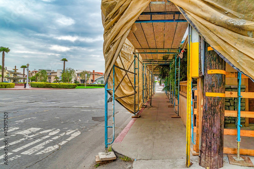 Fototapeta Building under construction with scaffolding on the sidewalk in Long Beach CA