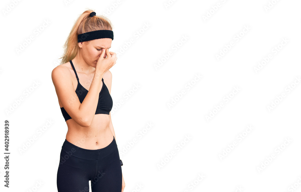 Young beautiful blonde woman wearing sportswear tired rubbing nose and eyes feeling fatigue and headache. stress and frustration concept. Young beautiful blonde woman wearing sportswear tired rubbing nose and eyes feeling fatigue and headache. stress and frustration concept.