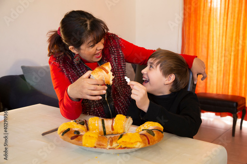 family shares traditional rosca de reyes. child finds doll in king's screw cake