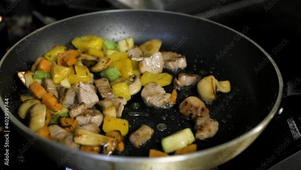 chef cooking hot wok with chicken and vegetables chef cooking hot wok with chicken and vegetables