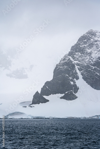 Rocky frozen landscape of Cuverville Island on a stormy day, Southern Ocean, Antarctica
 photo