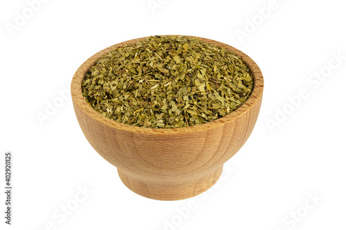 Dried leaves of yerba mate tea in wooden bowl isolated on white background. Nutrition. Traditional tea in South-America.