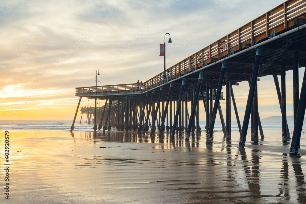 Sunset on the beach and pier. An iconic California wooden pier at 1, 370 feet long in the heart of Pismo Beach city in Central California coast.